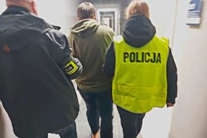 Policjant i policjantka prowadzą zatrzymanego mężczyznę.