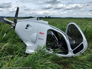 Ultralekki samolot leży w trawie.