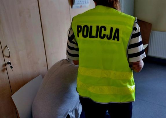 Policjantka stoi przy zatrzymanej kobiecie.