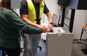 Policjant pobiera odciski palców.