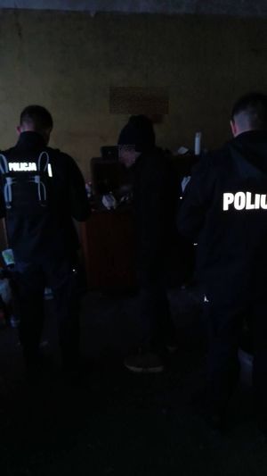 Dwóch policjantów stoi przy wychłodzonym mężczyźnie.