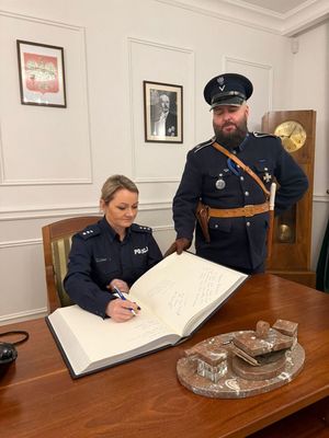 Wpis do księgi pamiątkowej przez Komendant i Dyrektor Szkoły.