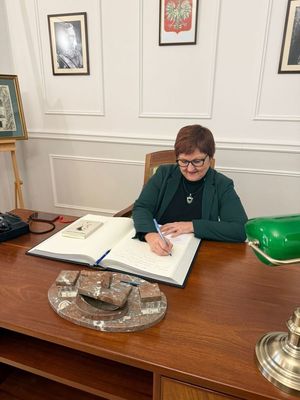 Wpis do księgi pamiątkowej przez Komendant i Dyrektor Szkoły.