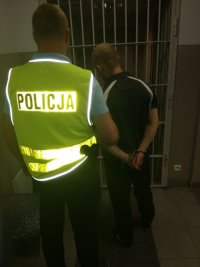 Policjanci prowadzą zatrzymanych mężczyzn