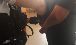 policjant rozkuwa kajdanki założone na nadgarstki zatrzymanego
