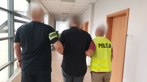 Funkcjonariusze Policji prowadzący zatrzymanego mężczyznę