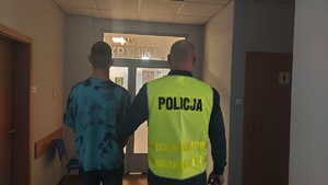 Funkcjonariusz Policji z zatrzymanym osiemnastolatkiem.