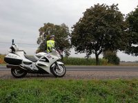 Policjant ruchu drogowego przy motocyklu policyjnym.