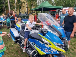 Chłopiec siedzący na motorze policyjnym.
