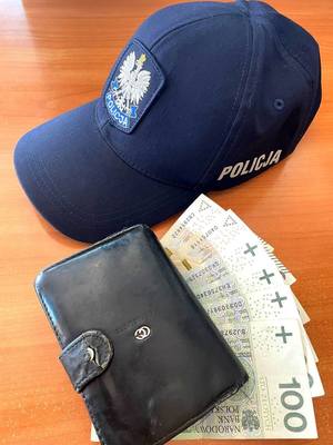 Czapka policyjna oraz banknoty i portfel.