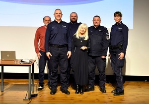 Policjanci stojący na scenie obok sędzi Anny Marii Wesołowskiej.