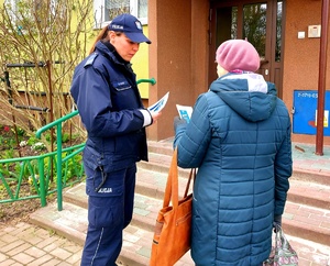 Policjantka wręczająca ulotkę seniorce.