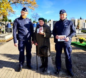 Dwóch policjantów i starsza pani z ulotką.