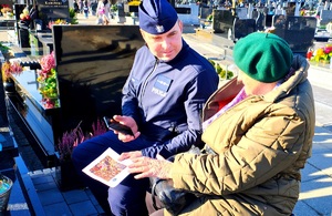 Policjant i starsza pani z ulotką.