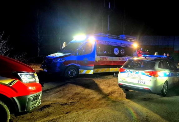 Radiowóz policyjny, strażacki i inne osoby.