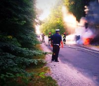 policjant ruchu drogowego zabezpiecza miejsce pożaru samochodu