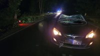 w nocy auto z rozbita szybą w oddali rower