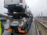 Uszkodzony samochód ciężarowy przewożący auta osobowe. Ponadto, uszkodzone auto znajdujące się na lawecie