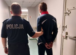 Policjant prowadzący do celi zatrzyamnego