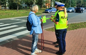 Policjanci rozdający elementy odblaskowe.