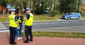 Policjanci rozdający elementy odblaskowe.