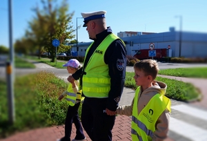 Policjanci i dzieci na spotkaniu w ramach akcji ,,Bezpieczna droga do szkoły”.