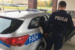 w radizowozie z tyłu siedzi zatrzymany obok umundurowany policjant