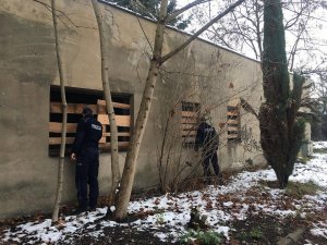 umundurowani policjanci zaglądają do środka pustostanu