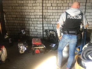 policjant wykonuje oględziny odzyskanych z kradzieży przedmiotów