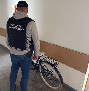 policjant stoi przy odzyskanym rowerze