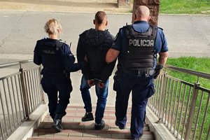 po schodach schodzi zatrzymany prowadzony przez dwóch umundurowanych policjantów