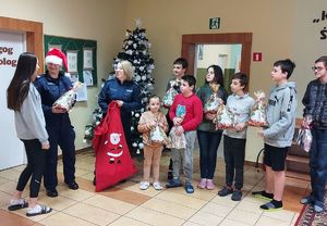 umundurowane policjantki odwiedziły dzieci z placówki opiekuńczej w Tomisławicach, wręczyły im prezenty, wspólnie stoją przy stoją przy udekorowanej choince