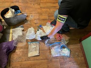 Czynności policjantów na miejscu ujawnienia narkotyków przechowywanych w torbach foliowych w pomieszczeniach mieszkalnych sprawcy.