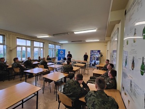 Naczelnik Wydziału Doboru Komendy Wojewódzkiej Policji w Łodzi młodszy inpektor Rafał Mrozowski opowiada o procesie rekcutacji do Policji, przed nim siedzą kandydaci.