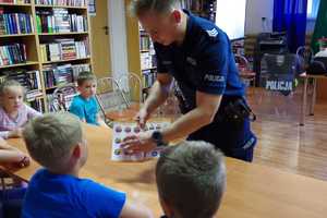 Policjant pokazuje swoim słuchaczom znaki, które najczęsciej można spotkać nad wodą.