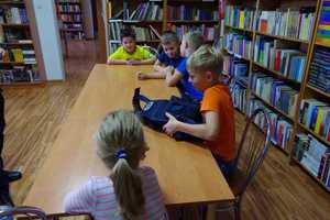 Dziecki oglądają policyjną kamizelkę kuloodporną.