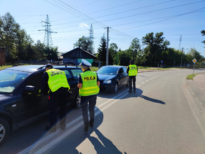 Policjantka wraz z dwoma funkcjonariuszami staży ochrony kolei podchodzą do kierowców by porozmawiać z nimi o kampanii bezpieczny przejazd.