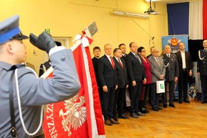 Dowódca pocztu sztandarowego oddaje honor. W tle widać zaproszonych gości.