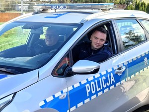 Policjanci siedzą w radiowozie.