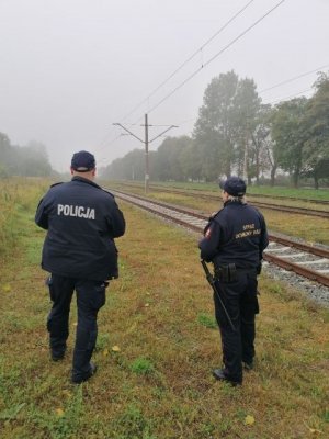 policjant wraz ze strażnikiem ochrony kolei przy torowisku.