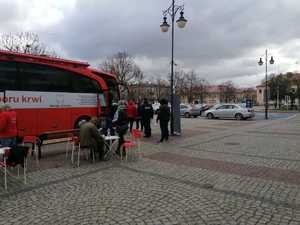 Na zdjęciu krwiodawcy gromadzący się w kolejce przed mobilnym punktem poboru krwi, wśród nich umundurowany policjant.