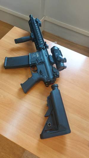 Zdjęcie leżącą na biurku replikę broni w kolorze czarnym.