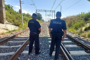 Policjant i strażnik ochrony kolei podczas kontroli infrastruktury kolejowej.