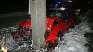 Czerwone auto wite w betonowy słup.