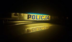 Podświetlony napis policja nocą.
