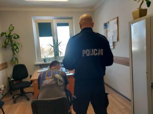 Policjant z zatrzymanym w pokoju podczas przesłuchania. Zabezpieczone maszyny.