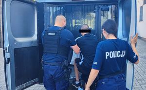 Policjanci z zatrzymanym obok radiowozu.