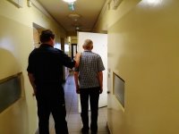 policjant prowadzi zatrzymanego