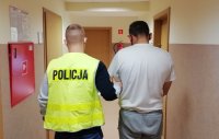 korytarz wewnątrz Komendy Powiatowej Policji w Kutnie, policjant prowadzi zatrzymanego