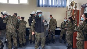 sala odpraw w KPP Kutno, uczniowie szkoły mundurowej przymierzają sprzęt policyjny, tarcze pałki, kaski